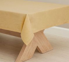 a wooden bench with a yellow tablecloth on it