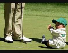 a little boy sitting on the ground with his hands out to catch a frisbee