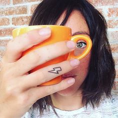 a woman holding a coffee cup in front of her face