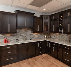 a kitchen with dark wood cabinets and marble counter tops