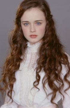 a woman with long red hair wearing a white shirt