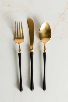 three forks and two spoons on a marble surface