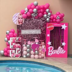 a barbie party with pink and silver decorations next to a pool filled with balloons, streamers and confetti