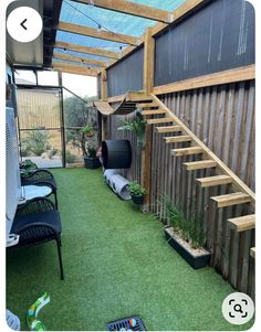 an outdoor area with green grass and wooden steps leading up to the second floor above