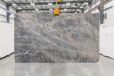 a large marble slab in a warehouse with yellow tags hanging from it's handles