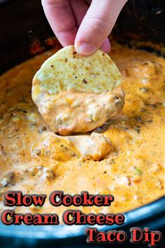 a hand dipping a tortilla chip into a slow cooker cream cheese taco dip