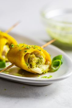 an appetizer is served on a white plate with green garnishes