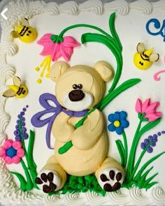 there is a cake decorated with a teddy bear and flowers