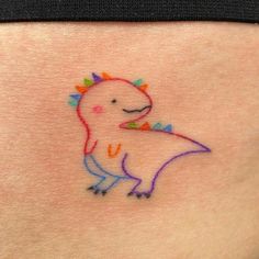 a small tattoo on the back of a woman's stomach with an image of a dinosaur