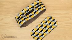 two yellow and black ties sitting on top of a wooden table