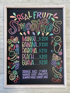 the menu for real fruit smoothies is shown on a blackboard with colorful lettering