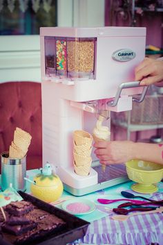 an ice cream maker is being used to make desserts on a table with other items