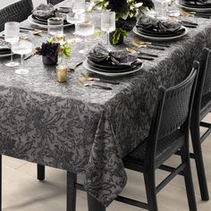 the table is set with black plates and silverware