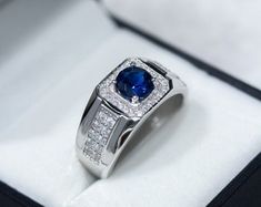 a blue and white diamond ring in a box