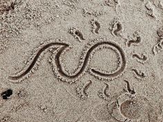 the word ao written in sand with footprints