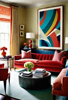 a living room filled with red couches and colorful paintings on the wall above them