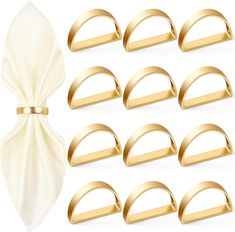 a set of twelve gold napkin rings with satine bow on them, isolated against a white background