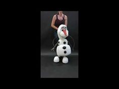 a woman standing next to a giant snowman