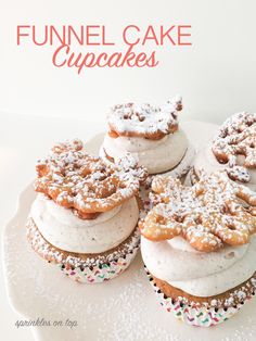 several cupcakes with white frosting and powdered sugar on top