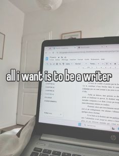 an open laptop computer sitting on top of a desk next to a white wall with the words, all i want is to be a writer