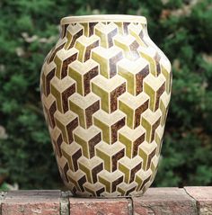 a white and green vase sitting on top of a table