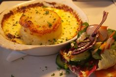 there is a small dish with food in it on the plate next to another bowl