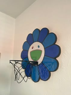 a blue and green flower on the wall above a basketball hoop