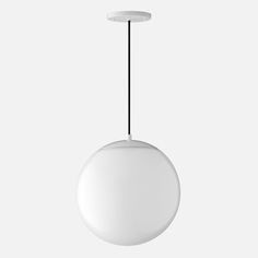 a white ball hanging from a black cord on a gray background with the light turned off