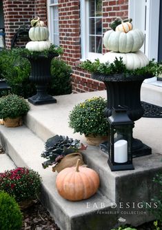 pumpkins and gourds are sitting on the steps in front of a house