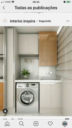 an image of a washing machine in a small room with white cabinets and wood accents