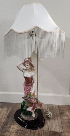 a figurine is holding an umbrella on top of a wooden floor next to a wall