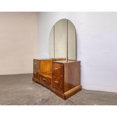 a wooden dresser with mirror on it in an empty room next to a white wall