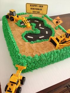 a birthday cake made to look like a construction site with tractors and road signs on it