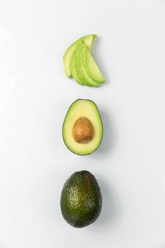 an avocado cut in half on a white surface