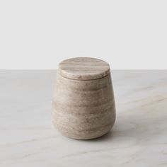 a white marble jar sitting on top of a table