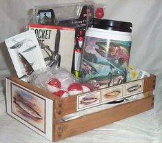 a wooden box filled with assorted items sitting on top of a white cloth covered floor