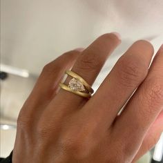 a woman's hand with a ring on it and a diamond in the middle