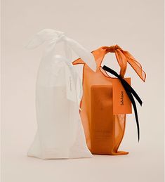 an orange and white bag sitting on top of a table next to a brown box