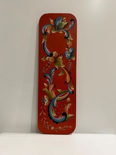 a red case with an ornate design on the front and back sides is sitting on a white surface