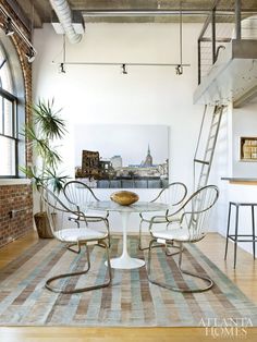 a dining room with chairs and a table in front of a large window that overlooks a cityscape