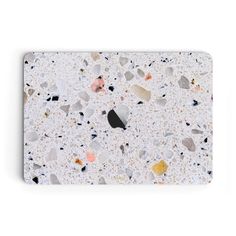 an apple laptop cover with various colored rocks on the front and back side, all covered in white speckles