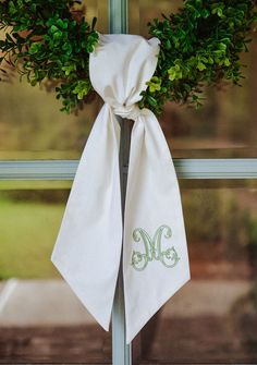 the monogrammed wreath is hung on the front door's window sill