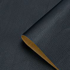 a close up view of a black leather material with a gold strip on the end