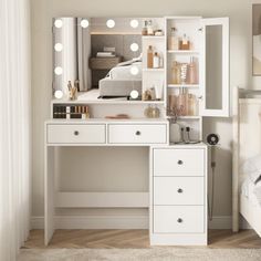 a white vanity with lights on it in a bedroom next to a mirror and bed