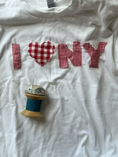 a t - shirt that says i love my mom with some sewing needles on it