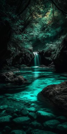 a waterfall in the middle of a forest filled with rocks and green water flowing down it's sides