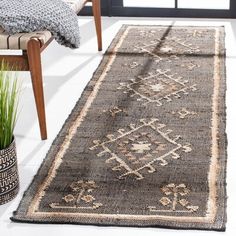 a large rug in the middle of a room with a chair and potted plant