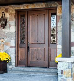 the front door to a home with yellow flowers