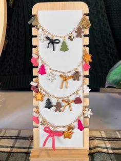 a wooden display with many different types of necklaces hanging from it's sides