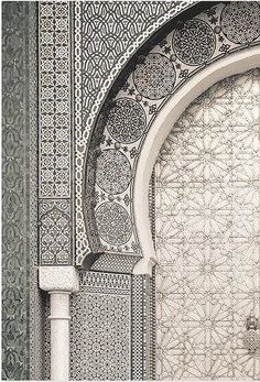 an intricately designed wall and door in the middle of a building